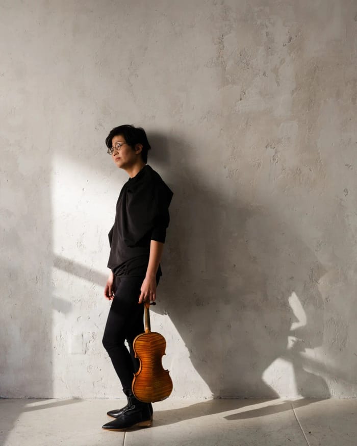 Clara Kim holding a violin